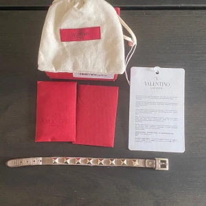 Valentino armband - Säljer detta superfina armband ifrån valentino i färgen ”poudre”. Slitet vid spännet som man kan se på näst sista bilden, annars i ganska fint skick. Nypris är 3085 och jag säljer för 800! Allt på bilden medföljer (box, äkthetsbevis m.m).