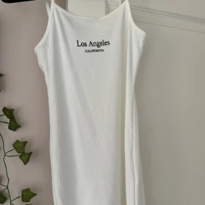 Los angeles klänning  - Denna underbara tröja är vit och kort med texten los angeles california. Jag säljer den eftersom den är för liten och använder den nästan aldrig. 