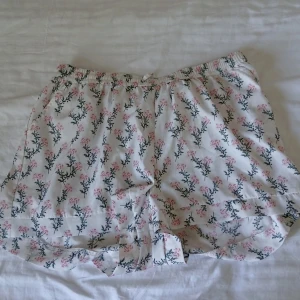 Vita/rosa shorts - Jättefina vita shorts med rosa blommor på. Storlek M men är stretchiga, så passar säkert L också. Säljer då de blivit för stora 💕 1 st för 50 eller alla 3 för 120! 