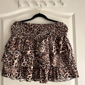 Leopardmönstrad kjol från New Collection - Säljer en superfin leopardmönstrad kjol från New Collection. Kjolen har flera lager med volanger och en elastisk midja som gör den bekväm att bära. Perfekt för en fest eller en utekväll! 🐆✨