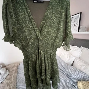 Grön mönstrad klänning från zara  - Grön mönstrad klänning från zara som är utsåld,aldrig använd.  Den är i storlek L men skulle mer säga att den sitter som en S/M. 
