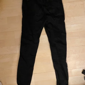 Svarta jeansbyxor - Säljer ett par svarta jeansbyxor. De är i bra skick och har en klassisk design med fem fickor och knappgylf. Perfekta för vardagsbruk eller en utekväll. Passar till det mesta och är ett måste i garderoben!