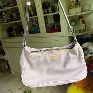 Lila Guess väska - Handväska från Guess Lite smutsig på tyget och har lite skav vid ett hörn annars fin