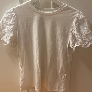 Vitt t-Short me mäster på ärmarna  - Jätte skön stretch tröja med fint mönster på axlarna