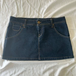 Lågmidjad jeanskjol - Lågmidjad kjol, helt oanvänd.  Storlek 36.  Midjemått: 39 cm rakt av