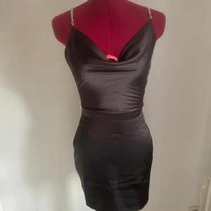 Satinklänning med strass - Aldrig använd då den är för liten. Storlek XXS. Har dragkedja där bak.