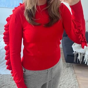 Topp - En unik tunnare stickad tröja i klarröd färg. Coola detaljer på ärmarna! Så snygg till långa kjolar eller jeans!!