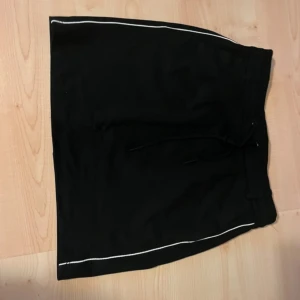 Svart kjol - Kort kjol med vit rand på sidorna.