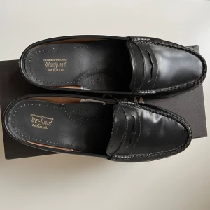 Slip-in loafers G.H.Bass - Säljer mina jättefina slip-in loafers/weejuns från G.H.Bass i svart skinn. Har enbart använts ett par gånger och är därför i väldigt fint skick. Storlek 40.