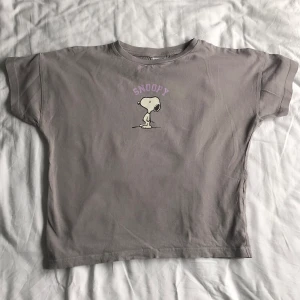 Snoopy babytee - Söt baby tee med snoopy tryck på. Kvalitet som ny typ oanvänd. Skönt material passar för småbarn men även större barn/ tonåringar+ med storlek S-M