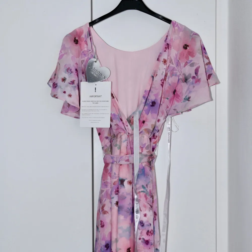 Säljer denna vackra blommiga klänning som är perfekt för våren och sommaren.  De 2 första bilderna är mina egna, de andra 2 är från GODDIVA’S sida.  Helt ny och är oanvänd.     . Klänningar.