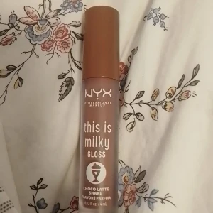 Nyx smink  - Säljer en Nyx "this is Milky gloss". Den är helt full. Bara testad ca 3 gånger. Den luktar som choklad. Säljer den för 50kr + frakt. Original pris är ca 120kr! 