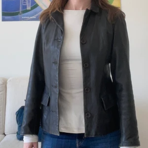 Svart kavaj i läder - Den snygga kavajen är köpt seccondhand men fortfarande i bra skick och hel! Från märket Elisa Landri