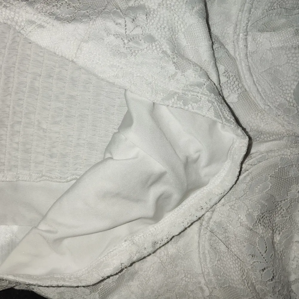 Säljer en vit topp från Gina Tricot i storlek M. Den är i utmärkt skick och har knappt använts. Toppen är inte genomskinlig tack vare det mjuka och sköna lagret under mönstret. Tillverkad av väldigt stretchig material.. Yläosat.
