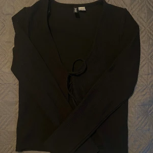 Jättefin topp med knytdetalj! Säljer billigt! 🫶🏼 - Fin svart topp med knytdetalj framme. Ribbad. Säljer då den inte kommer till användning längre, knappt några tecken på användning. 🫶🏼