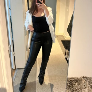 Skinnbyxor  - Skinnbyxor i läderimitation med slits nertill som går att stänga med dragkedja. Byxan stängs med dragkedja på sidan. Mycket bra skick och fraktkostnad tillkommer 🖤