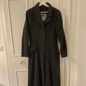 Lång kappa i ull - Varm figursydd lång kappa som sitter så fint! Är ner till anklarna på mig och jag är 167cm. Står storlek M men skulle säga att den passar XS-M.   Köparen står för frakt. Kan även mötas upp i Stockholm. 