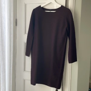Stickad ullklänning - Knälång klänning från COS. 3/4 ärm. 100% ull. Oanvänd. Rak modell. Färgen är burgundy 