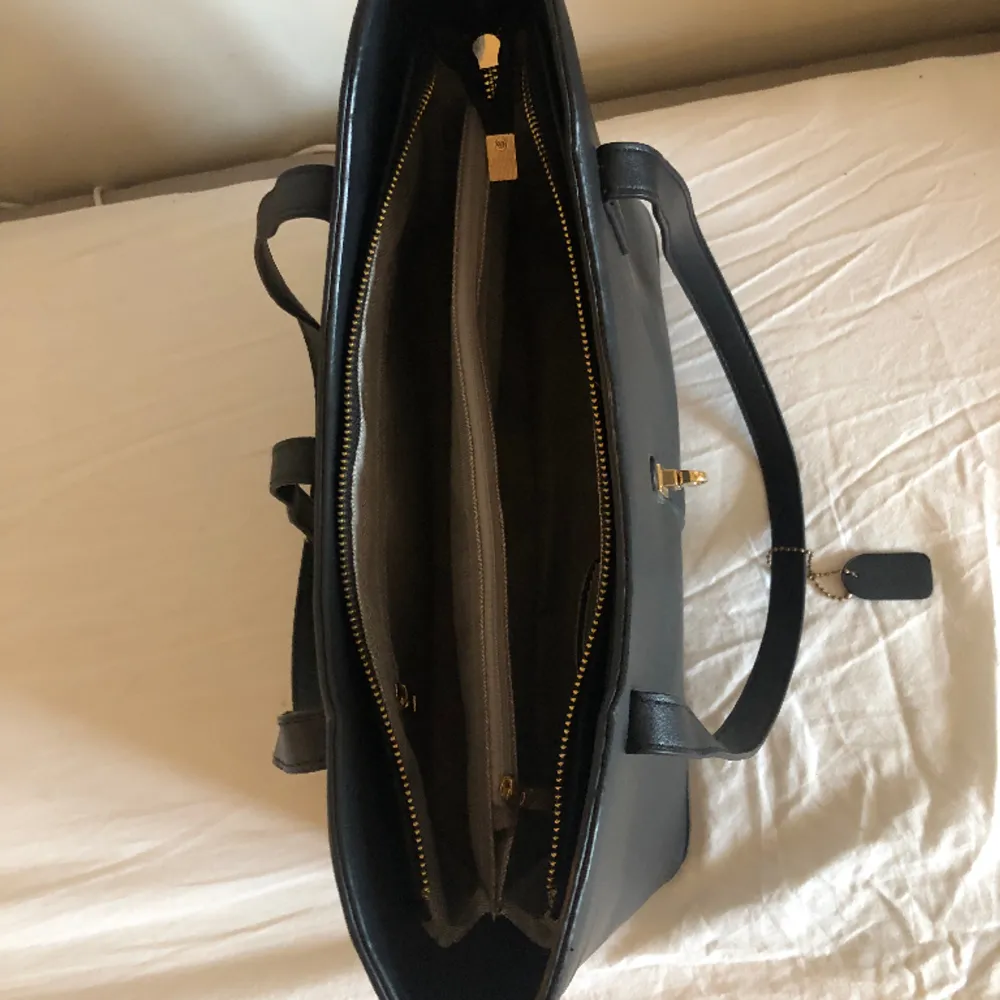 Handväska i PU-material med både blixtlåsstängning och metallknäppe.   Har två huvudfack som har en ficka med blixtlås som avdelare samt två mobilfickor och en mindre ficka med blixtlås.   Yttermått: L42xH24-28cm Vikt: ca 800g. Väskor.