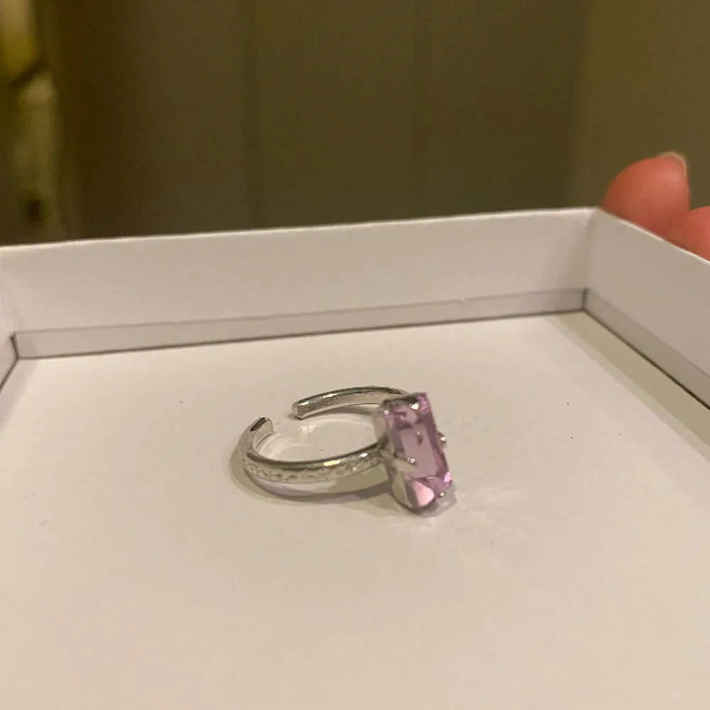 En silvrig ring med rosa sten från Caroline Svedbom! Fint skick!  Justerbar. Accessoarer.