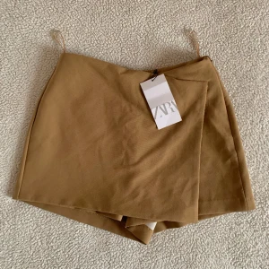 ZARA elegant brun shortskjol - Ny med tags kvar. Utan anmärkningar.
