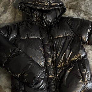 Vinterjacka storlek 150 - Använd 1 gång. Från lager 157 storlek 150 passar mig som jag xs. Väldigt glansig och sen är svart. Pufferjacka och den har fickor och är fodrad.