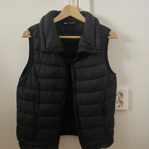 Svart dunväst - En svart dunväst från Zara. Har inte kommit till användning, därför säljer jag den. Västen är i mycket fint skick! 