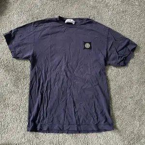 säljer min killes kläder!! marinblå stone island t-shirt i stoltek s. några små hål annars bra skick. nypris 1700.