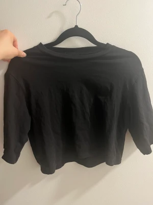 Kort t-shirt - En svart kort t-shirt från monki. Säljer då den inte kommer till användning.  Är i storlek xxs men passar även xs!  Skicka om du ha frågor! 💕