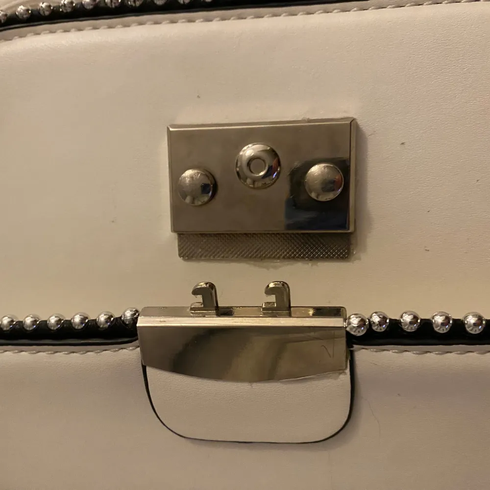 En fin men väl använd vit väska med silver detaljer. Väskan är 52cm runtom själva väskan för att få en bild av hur stor den är inuti. Ingen aning om nypris dock. Läs gärna min profil innan köp, kontakta eller buda istället för direkt köp❤️. Laukut & Käsilaukut.