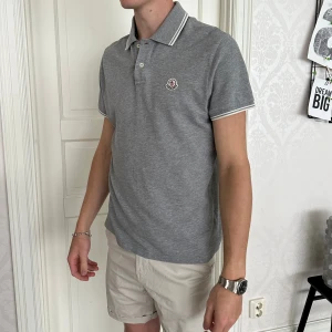 Moncler piké  - Moncler piké  Storlek L Skick 9/10  Färg Grå Nypris 3600kr  Modellen är 188cm och väger 75kg 