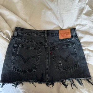 Levis jeanskjol  - Svart jeanskjol från Levis, W25 och midjemått ca 37 cm