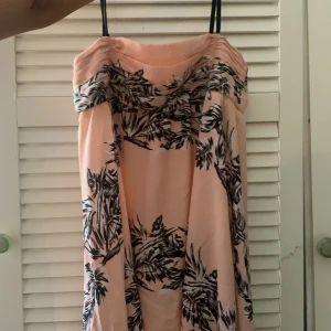 Rosa Zara klänning med svart vita blommor på - Mellan läng rosa klänning med svart vita blommor på, svarta band och dragkedja vid ryggen. Klänningen är somrig, snygg o söt.