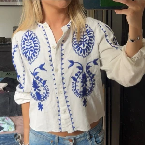 Vit blus - Vit blus med blå broderi mönster, har klippt bort lappen men tror de är storlek s