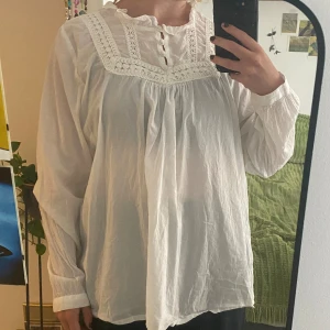 Vit blus - Söt vit blus med fina spetsdetaljer! 100% bomull.   OBS: Kommer vara bortrest en del under sommaren så är inte alltid tillgänglig att posta/skicka fler bilder direkt. Går bra att skriva/köpa ändå, men kan dröja upp till en vecka innan jag kan skicka.