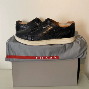 Prada Leather Sneakers  - Hej, säljer ett par svarta Prada sneakers i elegant läder. Enormt kvalitativa, bekväma och stilrena. Dustbag medkommer. Använda men i okej skick. Passar till allt & lätta att stylea. Storlek 43. Nypris över 7000kr. Pris kan diskuteras. Hörs i DM! 