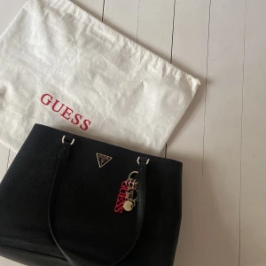 Guess väska - Lägger upp den här igen pågrund av att jag nu har hittat dustbag och nyckelring som ingår med väskan! Den är i bra skick, en liten del av dragkedje grejen där bak har gått av men annars är de inget fel på den! Nypris ca 1000kr
