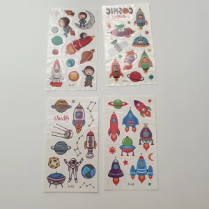 4st rymdskepp, rymden tatuering  - Tatuering/tattoo  Motiv: rymdskepp, planeter, astronauter  Antal: 4st ark Storlek: ca 6,7×12cm Skick: nya/oanvända  Tillfälliga tatueringar du sätter på kroppen med hjälp av vatten 