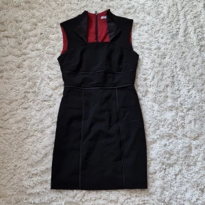 Andrew marc klänning - Svart klänning med röd insida. Lång dragkedja på baksidan och detaljer upptill (de bild), samt i midjan . Bra skick. 