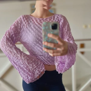 Söt långärmad topp - Ljuslila/rosa topp i ”skrynkligt material” den ser pytteliten ut och sen blir den stor när man tar på sig den:)  Tunnt material! Söt med en spetsbh under eller linne☺️  Nyskick 