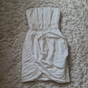 Ärmlös klänning - Ärmlös klänning med structured material. Den har silikon efter linjen på överdelen så den ej glider ner. Går omlott längst ner (se bild), mönstret ser man också på bilderna. Pris kan diskuteras 