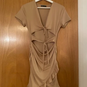 Beige klänning - Beige klänning från Shein. Söt med unika detaljer men inte min stil, har därmed aldrig använt den och därför säljer jag den💓