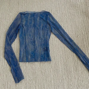 Meshtop - Långärmad meshtopp i blå från Weekday. Fint skick, använd 1-2 gånger.