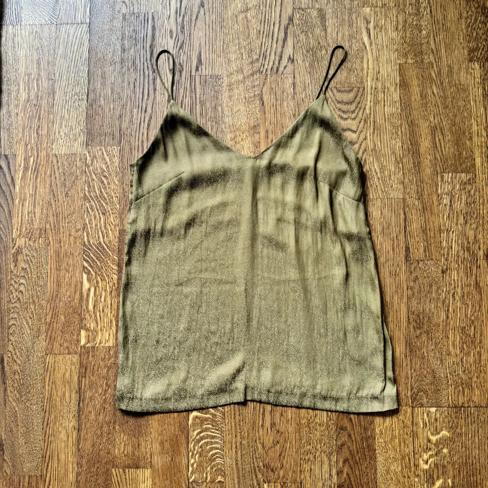 Olivgrönt silkigt linne som skiftar i brons. Tunt och ser lyxigt ut. Perfekt till sommaren 🤎  Material polyester. Toppar.