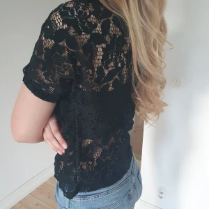 Spetsig svart tröja - Svart mönstrig t-shirt i storleken S. Jätte fin och lufgig passar till allt!