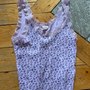Urban outfitters linne - Jättegulligt ribbat linne i fin färg och spets. Stretchig så passar nog även S. Längd ca 41/42cm, bredd ca 27cm. 95% bomull, 5% elastane.