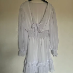 Studentklänning  - En helt ny studentklänning med rosettknytning och volanger. Den skickas i originalpåsen men kom utan prislapp. Säljes då den var för stor! 