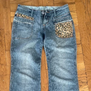Lågmidjade leopard jeans - Säljer dessa jätte fina bootcut jeans med leopard detaljer. Midjemått: 39cm, Innerbenslängden: 76cm. Jag hittade dem på Plick men tyvärr har de inte kommit till användning. 