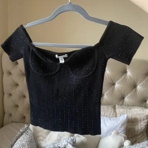 Svart glitter topp - En svart topp med lite glitter detaljer. Jätte fin! Bra skick då den nästan inte är använd