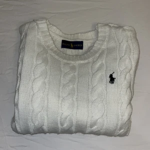 Kabel stickad Polo Ralph Lauren  - En stilren vit-beige Polo Ralph Lauren kabel stickad tröja i storlek S. Oanvänd pga att den ej passa. Pris går att diskuteras. Bra passform för killar, funkar även som lite oversized för tjejer!